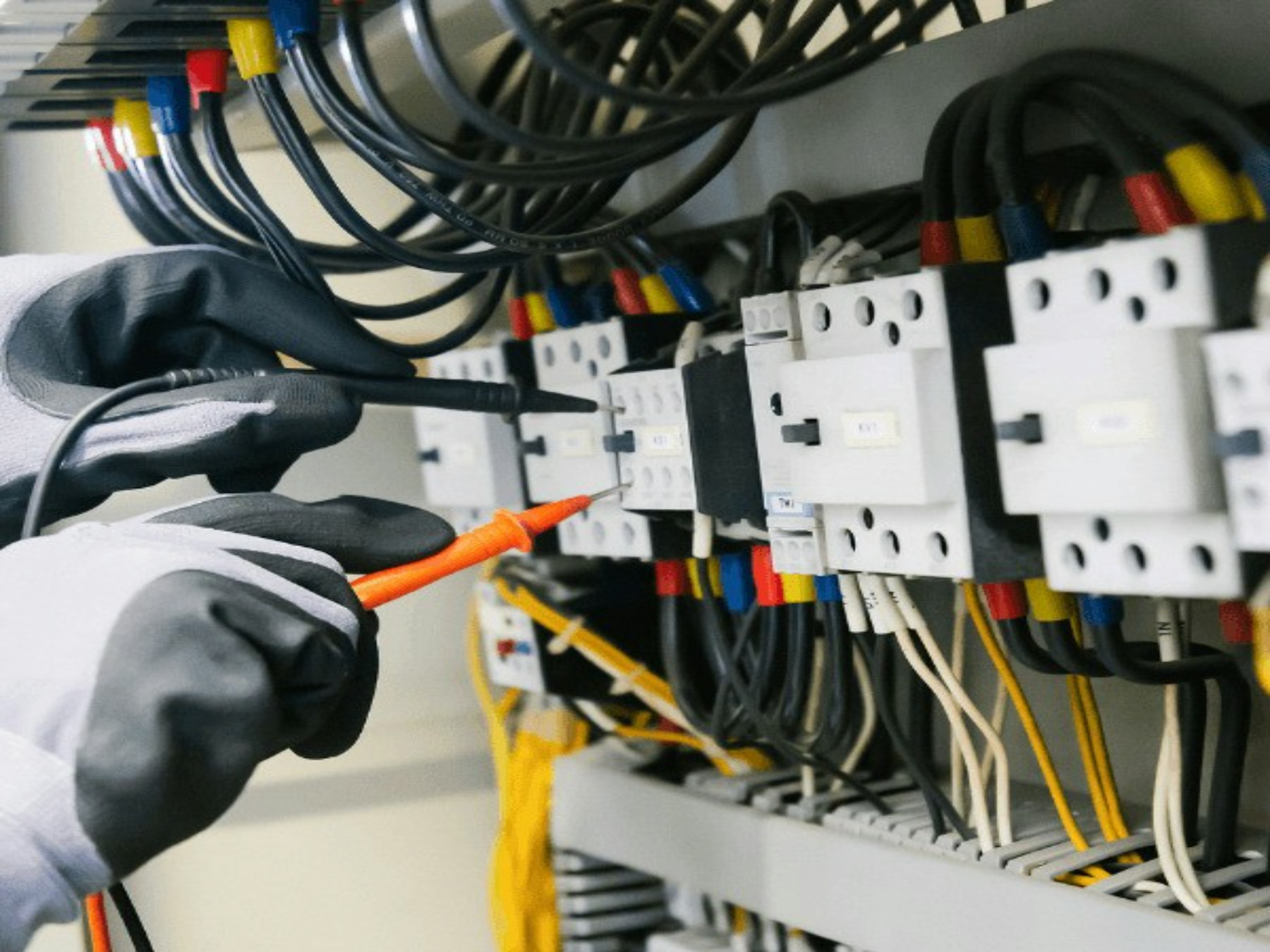 Gloved hands using insulated probes to test electrical protection equipment